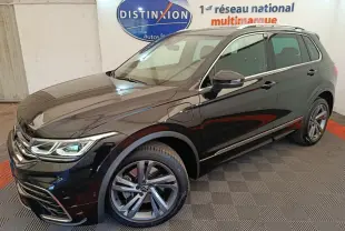 Vue 3/4 avant droit du Volkswagen Tiguan 1.4 eHybrid noir avec jantes alliage et détails R-Line en showroom.