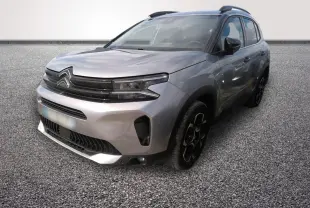 Vue 3/4 avant droit d'un Citroën C5 hybride gris clair avec calandre noire et jantes noires distinctives.