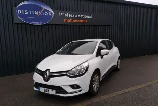 Renault Clio IV Société blanche vue 3/4 avant droit, garée devant un mur noir avec enseigne Distinxion.