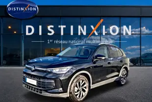 Volkswagen Tiguan noir 2025 en 3/4 avant droit, avec jantes spécifiques et calandre moderne devant un showroom Distinxion.