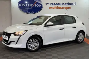 Peugeot 208 blanc vue de profil droit en intérieur, avec phares allumés et jantes alliage simples.