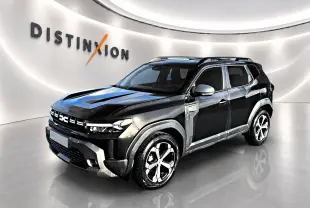 Dacia Duster noir en 3/4 avant droit, avec jantes alu distinctives et barres de toit visibles en showroom.