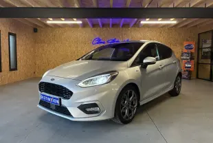 Ford Fiesta 1.0 EcoBoost 95 ST Line gris vue 3/4 avant droit dans un showroom avec éclairage intérieur.