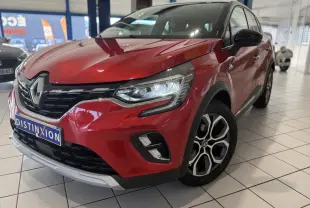 Vue 3/4 avant droit d’un Renault Captur rouge foncé avec jantes alliage et calandre chromée en showroom.