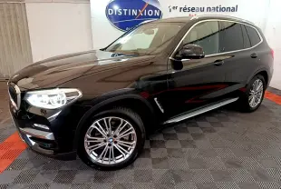 BMW X3 xDrive20d noir en 3/4 avant droit avec jantes alliage et phares LED allumés en intérieur showroom.