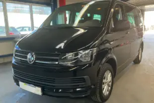 Volkswagen Multivan T6 noir vu en 3/4 avant droit dans un garage avec calandre et phares nets.