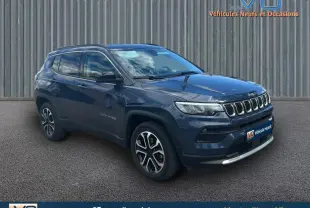 Jeep Compass bleu 3/4 avant droit avec barres de toit et jantes 18 pouces, stationné devant un mur métallique.