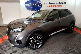 Peugeot 2008 gris foncé vue 3/4 avant droit, avec jantes noires et toit noir dans un showroom intérieur.