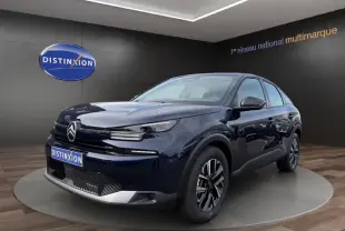 Citroën C4 hybride bleu en 3/4 avant droit avec jantes alliage et feux LED dans un showroom.