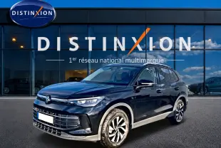 Volkswagen Tiguan 1.5 eTSI noir en 3/4 avant droit, avec jantes spécifiques et calandre moderne devant showroom Distinxion.