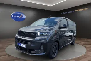 Vue 3/4 avant droit d’un Citroën Jumpy gris foncé avec calandre noire et jantes sombres, en showroom.