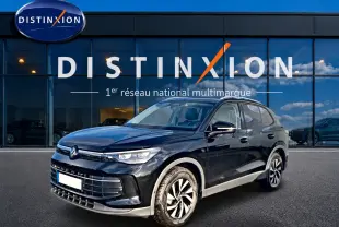 Volkswagen Tiguan noir 2025 en 3/4 avant droit, avec jantes spécifiques et calandre moderne devant showroom Distinxion.