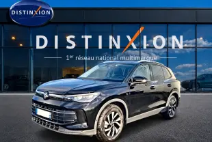 Volkswagen Tiguan noir 2025 en 3/4 avant droit, avec jantes distinctives et calandre moderne devant showroom Distinxion.