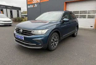 Volkswagen Tiguan bleu nuit métallisé vu en 3/4 avant droit avec jantes alliage et feux LED allumés.