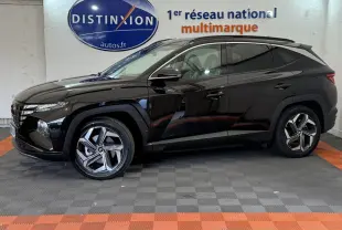 Profil droit d'un Hyundai Tucson noir 2022 avec jantes alliage modernes, stationné en intérieur showroom.