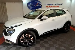 Vue 3/4 avant droit d'un KIA Sportage blanc 2022 hybride rechargeable, avec jantes noires et feux LED distinctifs.