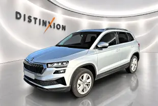 Vue 3/4 avant droite d'un Skoda Karoq gris 2025 avec calandre noire et jantes alu cinq branches.