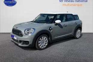 Vue 3/4 avant droite d'une MINI Countryman Cooper SE hybride rechargeable en Moonwalk Grey avec toit blanc et jantes alu design Pin Spoke.