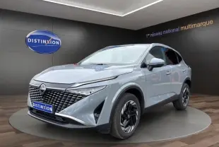 Nissan Qashqai gris foncé en 3/4 avant droit, avec calandre noire texturée et jantes noires stylisées.
