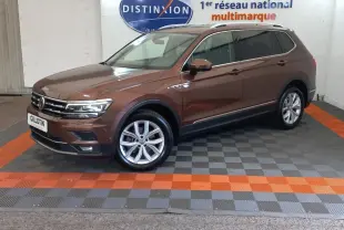 Volkswagen Tiguan Allspace marron vue de profil côté gauche en intérieur avec jantes alliage et toit chromé.