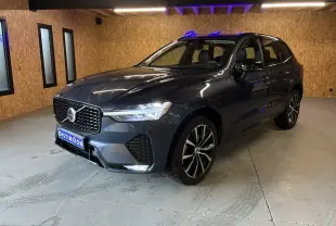 Vue 3/4 avant droite d'un Volvo XC60 bleu avec calandre noire laquée et jantes alliage 20 pouces bicolores.