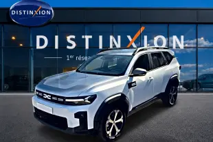 SUV Dacia Bigster blanc en 3/4 avant droit, avec barres de toit et jantes alu noires et argentées.