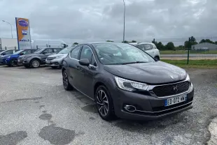 DS4 gris clair vue 3/4 avant droit sur parking avec calandre noire et jantes alliage distinctives.