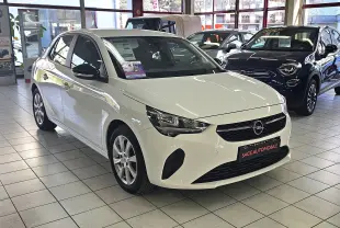 Opel Corsa blanc glacier vue 3/4 avant droit en showroom, avec jantes alliage et calandre noire.