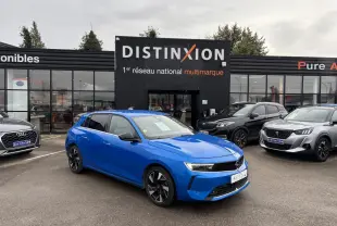 Opel Astra VI bleu clair vue 3/4 avant droit avec jantes noires devant concession Distinxion