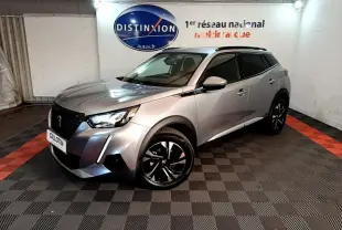 Peugeot 2008 gris clair en 3/4 avant droit, avec jantes noires et toit noir dans un showroom.
