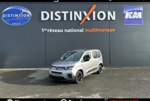 Citroën Berlingo gris clair vu en 3/4 avant droit, avec jantes noires et portes coulissantes visibles.