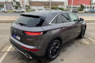 Vue 3/4 arrière droite du DS7 Crossback E-Tense gris platinium avec feux arrière LED et jantes noires brillantes.