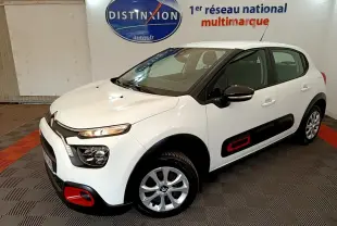 Citroën C3 blanche vue 3/4 avant droit, avec inserts rouges distinctifs sur les protections latérales et pare-chocs.