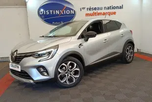 Renault Captur Intens E-TECH gris clair en 3/4 avant droit, avec jantes alliage et feux LED allumés.