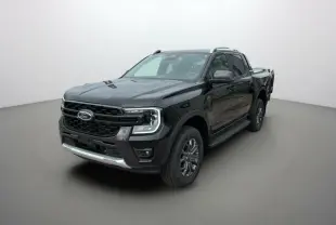 Ford Ranger 2.0 205 Wildtrak Plus noir agate en 3/4 avant droit avec barres de toit et marchepieds visibles.