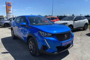 Peugeot 2008 bleu en 3/4 avant droit, avec calandre noire et feux LED, stationnée en extérieur au soleil.