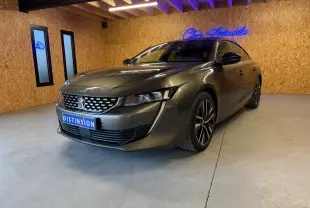 Peugeot 508 gris en 3/4 avant droit dans un intérieur avec murs en bois et éclairage néon bleu.