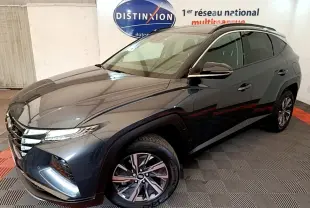 Vue 3/4 avant droit du Hyundai Tucson 1.6 Hybrid 230 Creative gris foncé, avec jantes alliage et vitres teintées.