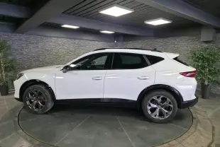Vue de profil côté gauche d'un CUPRA Formentor blanc avec jantes alliage noires et bas de caisse contrastants noirs.