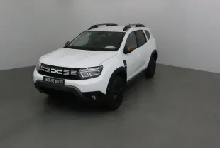 Dacia Duster blanc 2024 en 3/4 avant droit avec rétroviseurs bronze et jantes noires dans un studio gris.