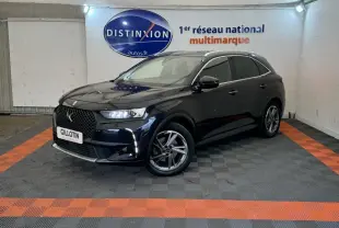 DS7 Crossback E-TENSE bleu en 3/4 avant droit, avec calandre distinctive et feux LED allumés dans un showroom.
