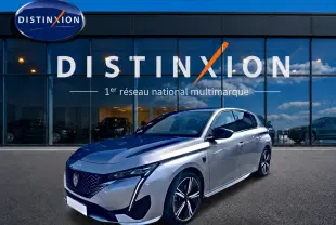 Peugeot 308 1.2 hybrid gris vue 3/4 avant droit, jantes alu et phares LED devant showroom Distinxion.