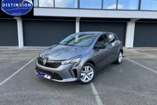 Renault Clio V gris schiste vue 3/4 avant droit, avec jantes alliage et feux LED distinctifs sur parking.