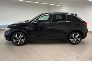 Vue de profil côté gauche du Volkswagen T-Roc 1.5 TSI 150 DSG7 R-Line Edition noir intense dans un intérieur neutre.