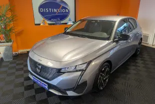 Peugeot 308 2025 gris Artense vue 3/4 avant droit avec calandre distinctive et jantes alliage noires.