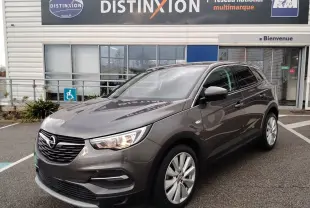 Opel Grandland X gris platinium vu en 3/4 avant droit, avec calandre noire et jantes alliage argentées.