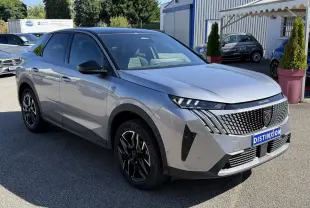 Peugeot 3008 gris clair en 3/4 avant droit, avec calandre noire distinctive et jantes noires stylisées.