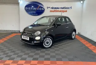 Fiat 500 noire vue en 3/4 avant droit dans un showroom avec jantes alliage et phares ronds allumés.