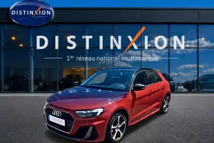 Audi A1 Sportback rouge et noir vue 3/4 avant droit devant une vitrine Distinxion.
