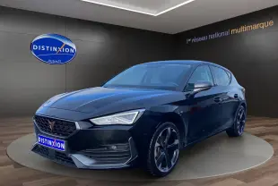 Vue 3/4 avant droite d'une CUPRA Leon noire 2023 avec jantes noires et calandre distinctive en showroom.